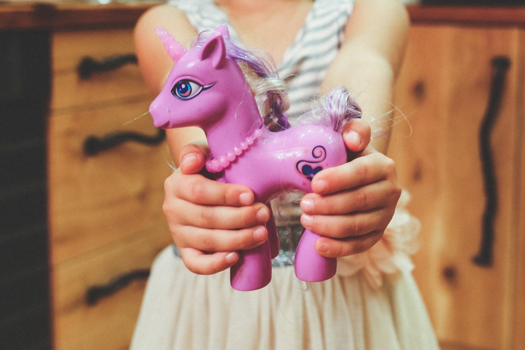 Girl holding a plastic unicorn