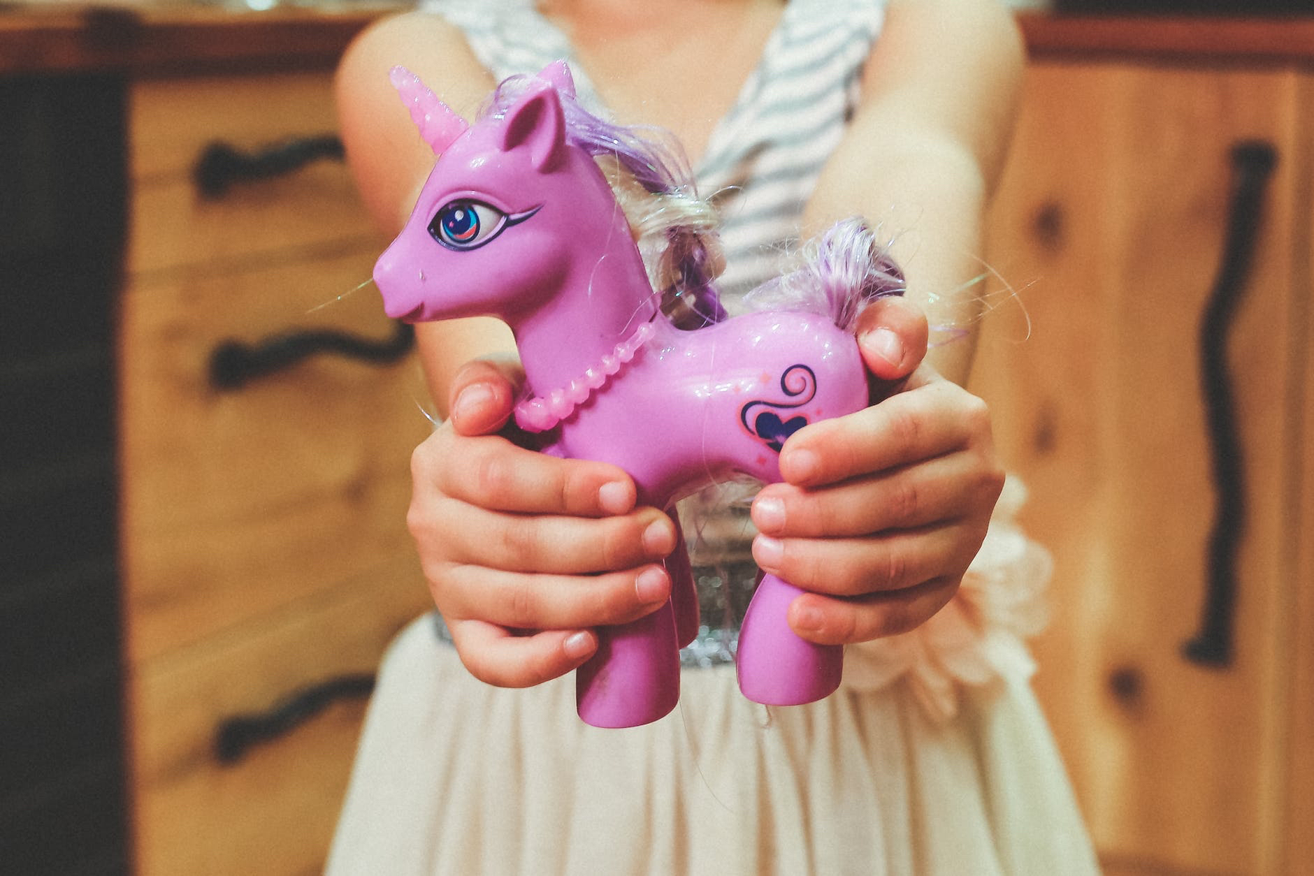 Girl holding a plastic unicorn